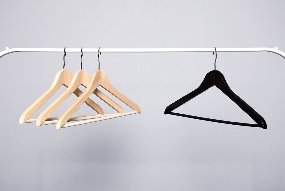 Three beige and one black clothes hangers