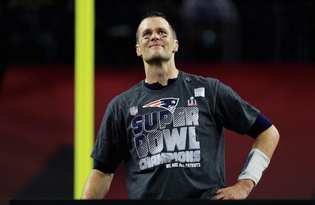 Tom Brady stands on the Super Bowl stage with tears in his eyes.