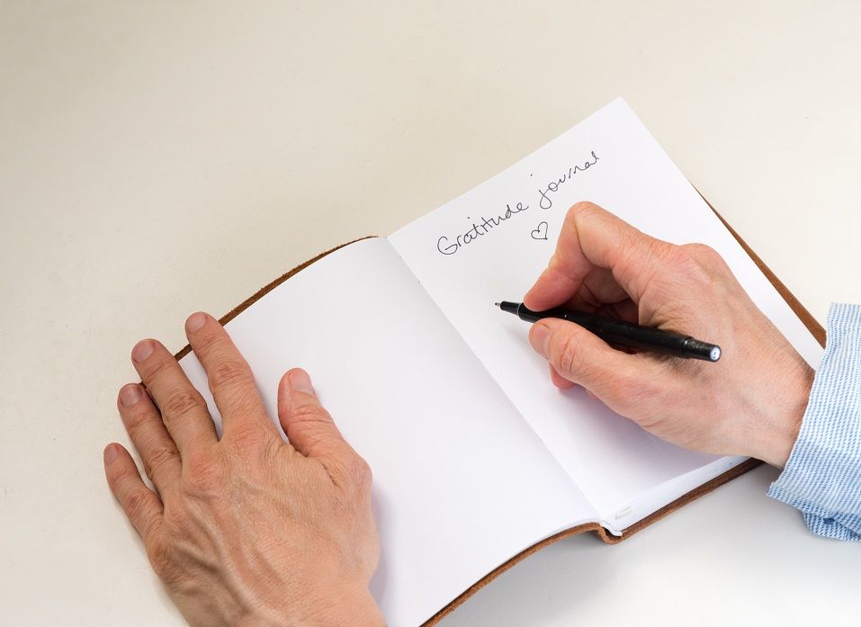 A middle aged woman writes in her gratitude journal