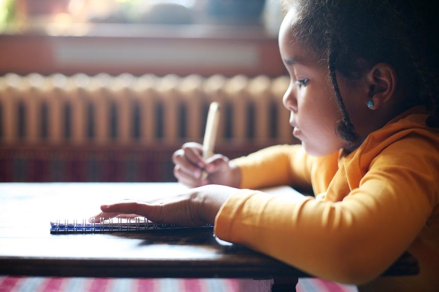 Little African-American girl writing in the classroom