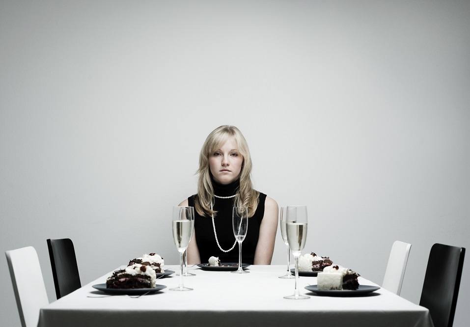 Woman sits alone at dinner table