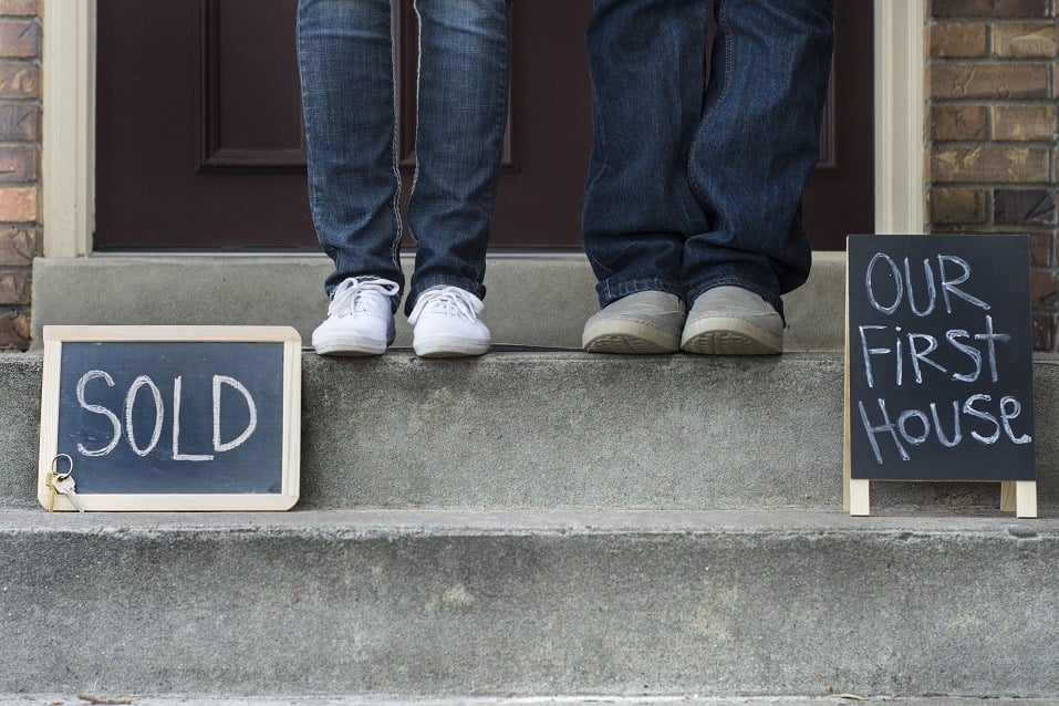 couple's feet in front of house
