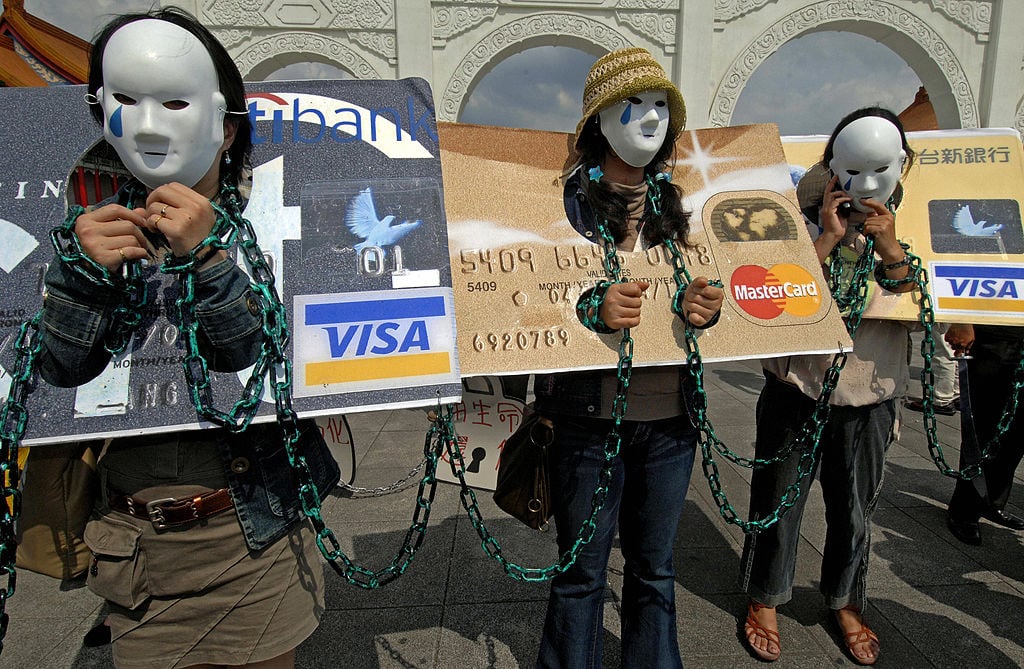 Consumers who are in credit card debt, referred to as "credit card slaves," take part in a demonstration.