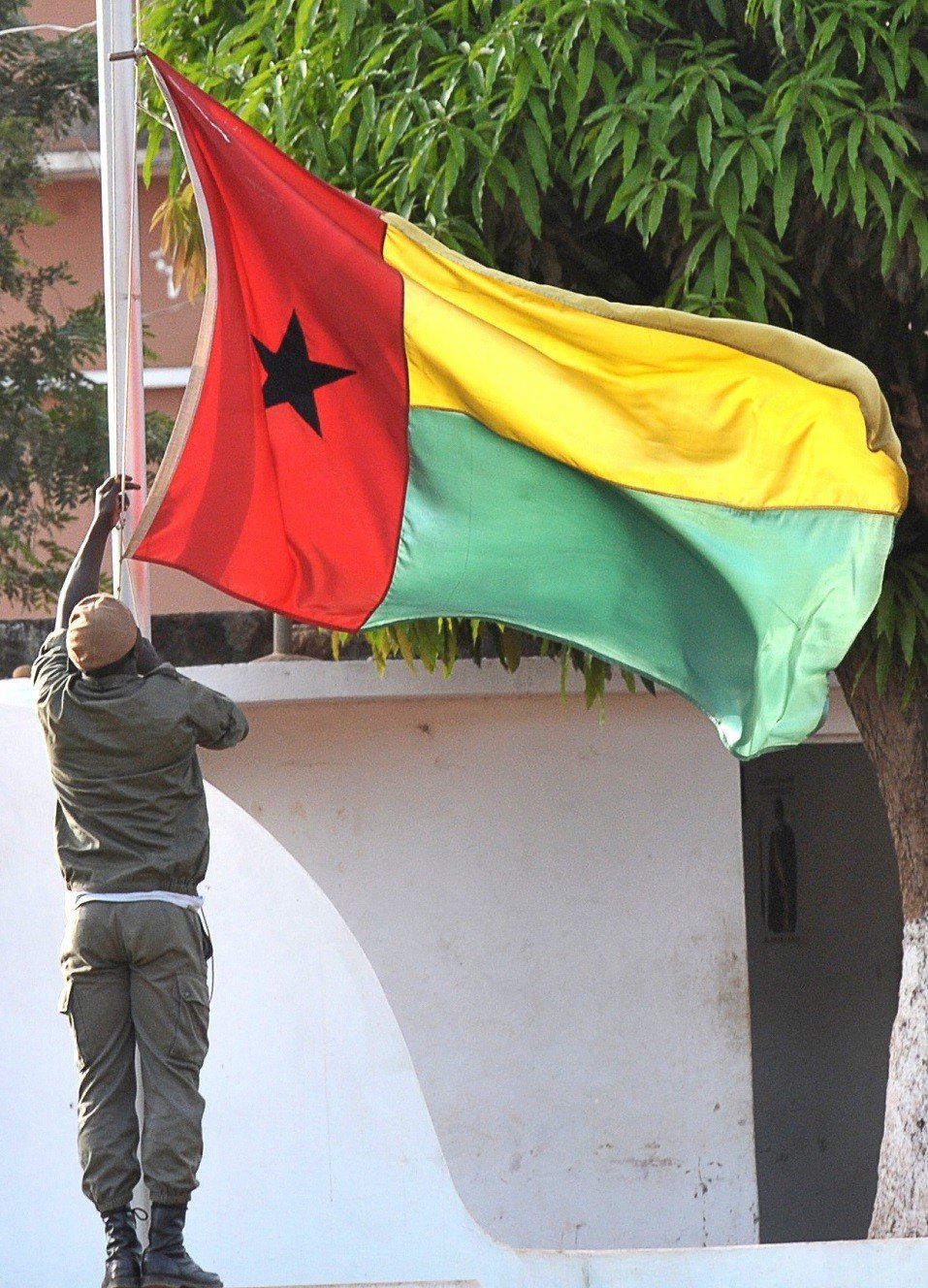 A soldier of Guinea-Bissau lowers the flag