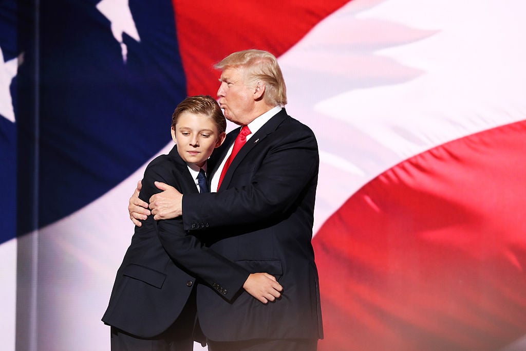 Barron Trump embraces Donald Trump on stage.
