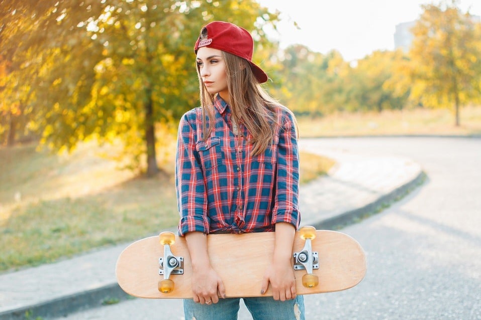 young woman posing with a skateboard