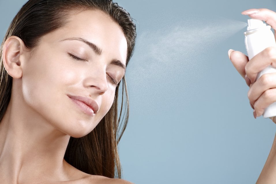 Woman applying spray water treatment