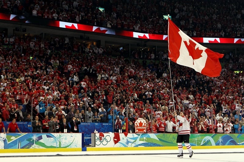 Sidney Crosby of Canada waves a national flag.