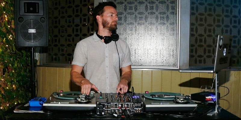 Danny Masterson is working at a DJ turntable 