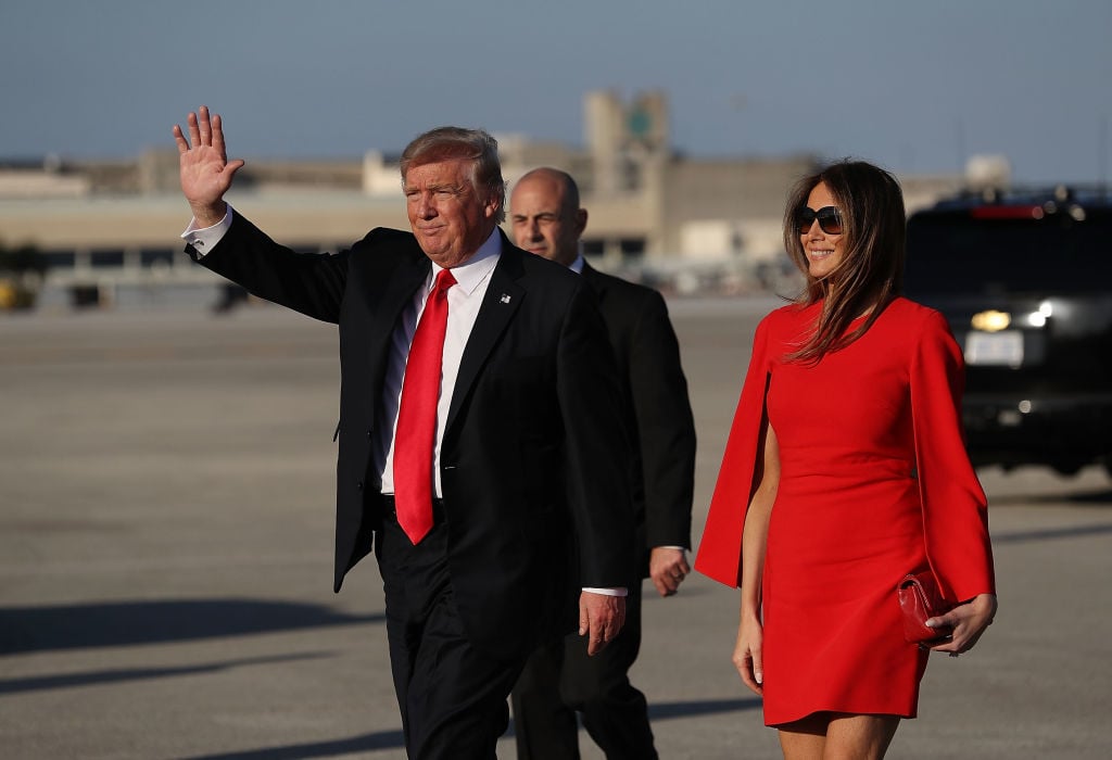 U.S. President Donald Trump walks with his wife Melania Trump.