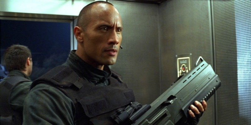 Dwayne Johnson is holding a large gun in Doom.