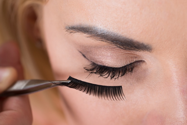 false eyelashes being put on woman's eye