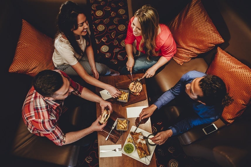 Overhead view of a group of friends having a meal at a restaurant