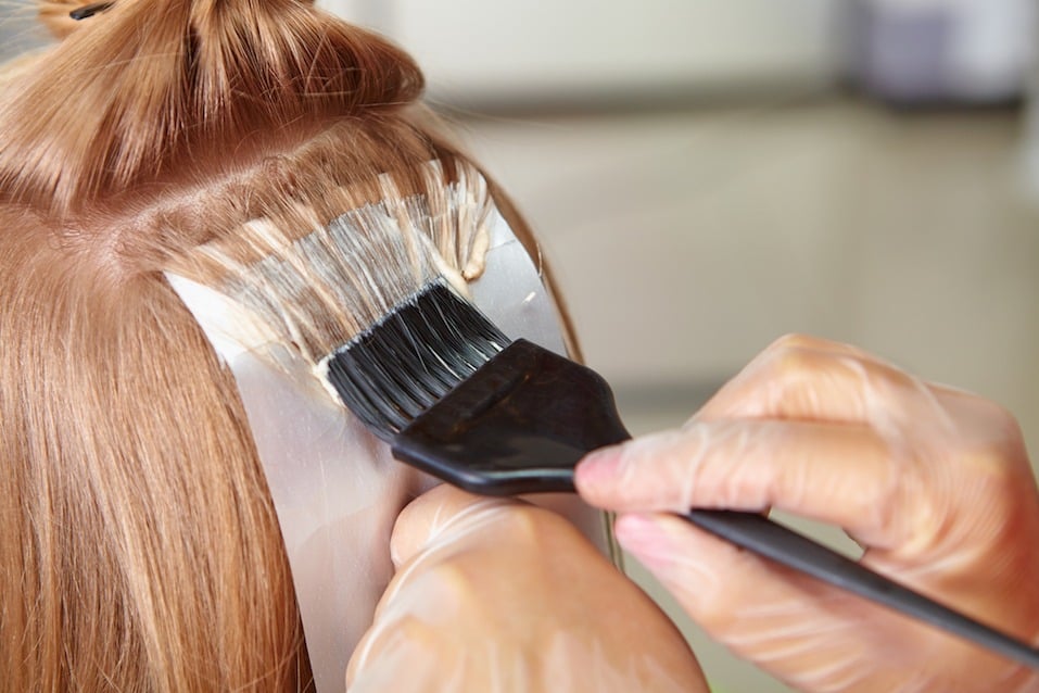 a stylist painting on hair color Hair Coloring