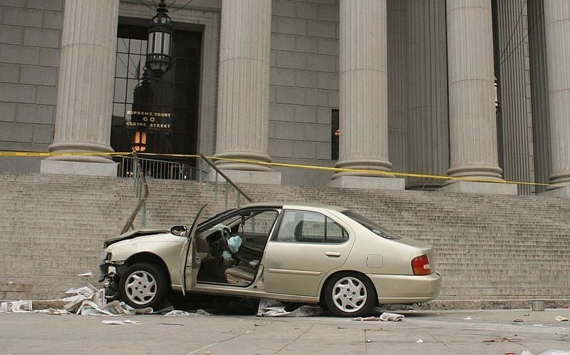NEW YORK - APRIL 11: Emergency tape surrounds the scene where a car that crashed into the base of the steps of the state Supreme Court building in downtown Manhattan April 11, 2008 in New York City. The car jumped the sidewalk, smashed into a coffee cart and went up several steps, pinning a man in the process. At least six people were injured.