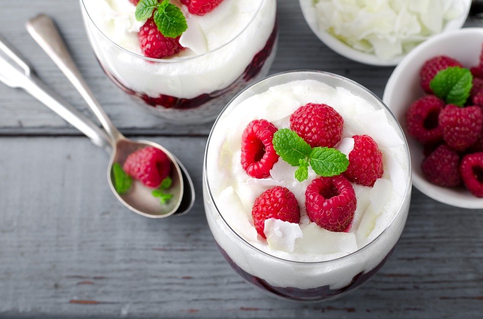 Two bowls, top-down view, filled with yogurt and fruit.