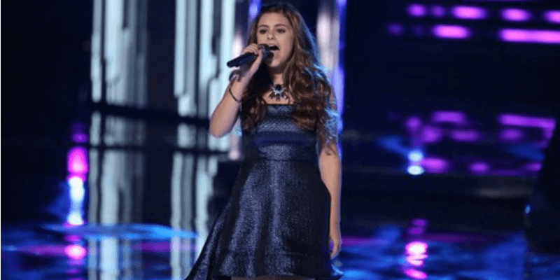 Jacquie Lee is singing in a blue dress on The Voice.
