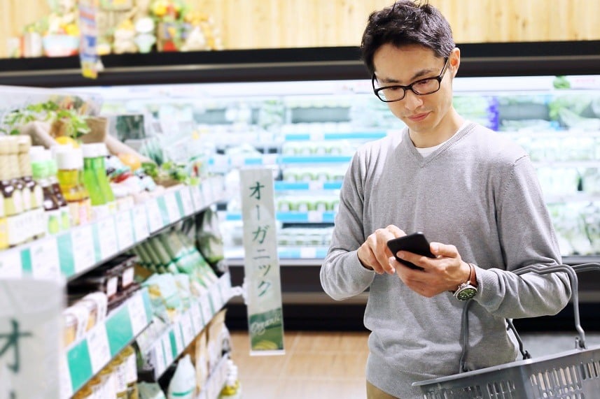 Young man using cellphone in a grocery store