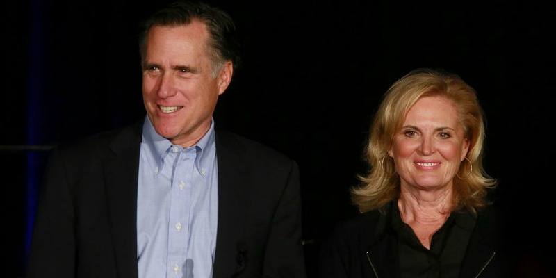 Mitt and Ann Romney are on stage smiling at the crowd.