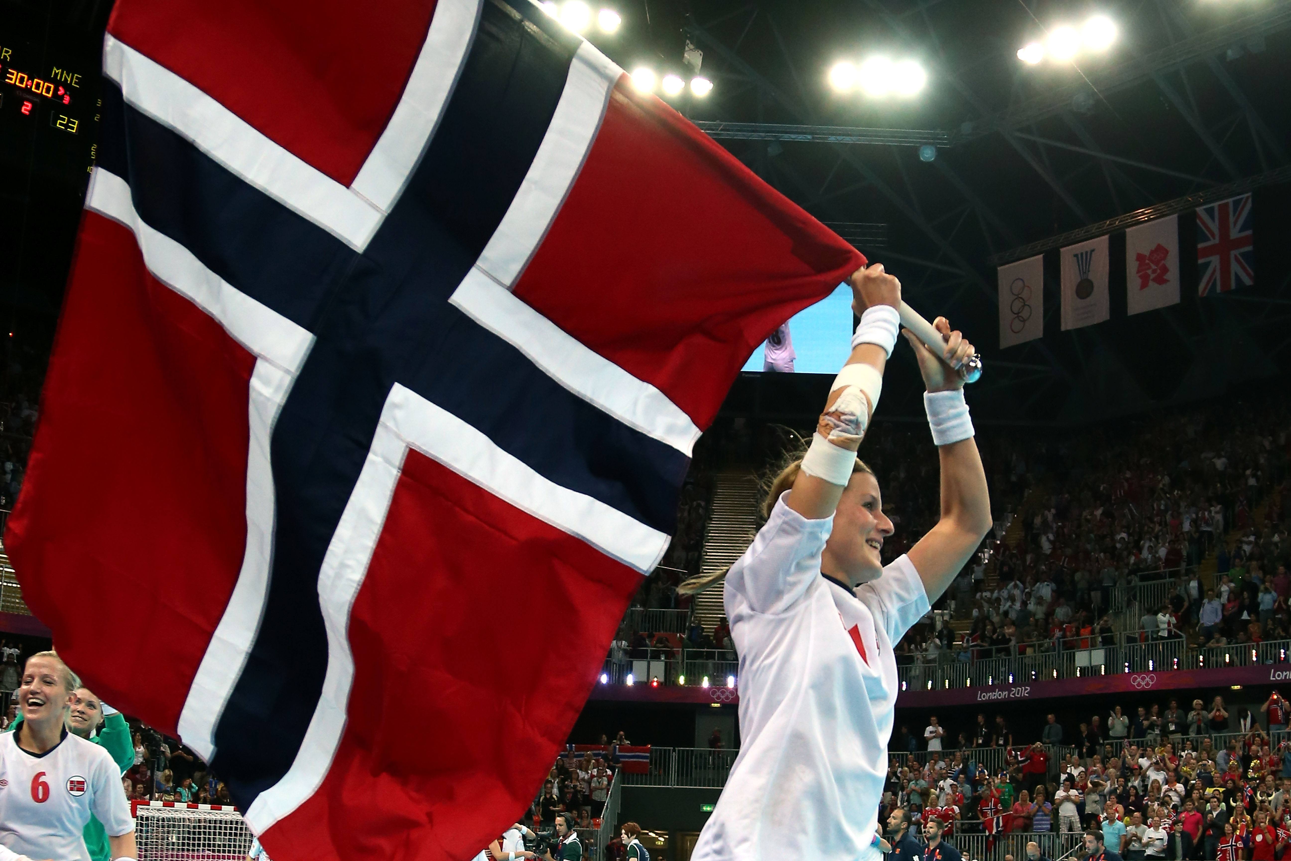 A Norwegian Olympian celebrates with her country's flag