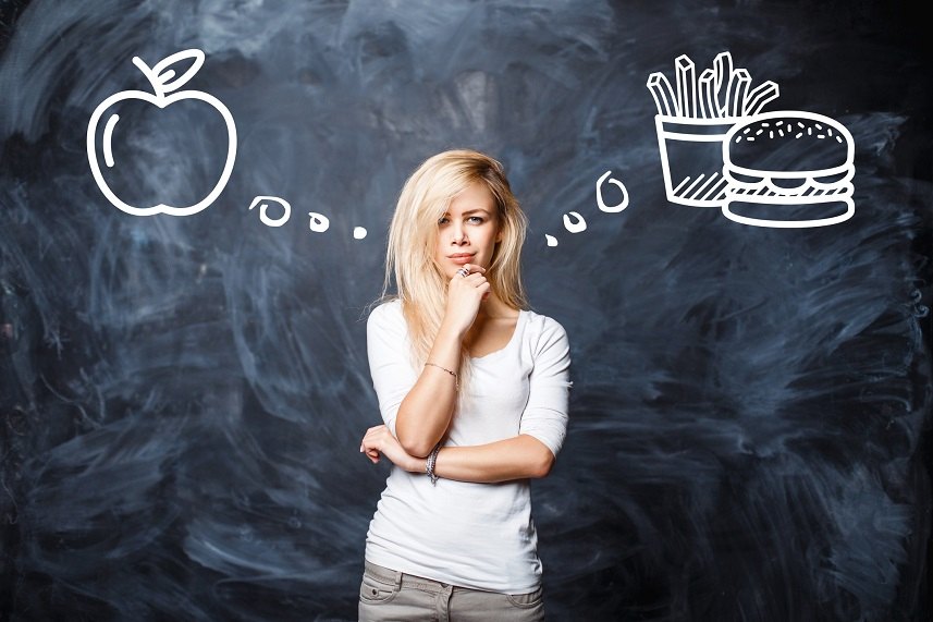 Woman makes a choice between bad food and healthy eating Woman makes a choice between bad food and healthy eating