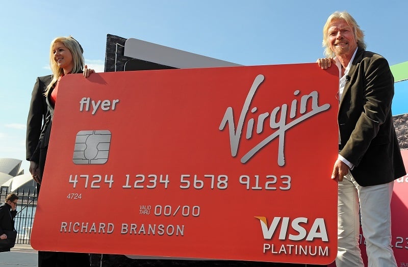 Virgin founder Richard Branson holds a giant Virgin Money credit card.