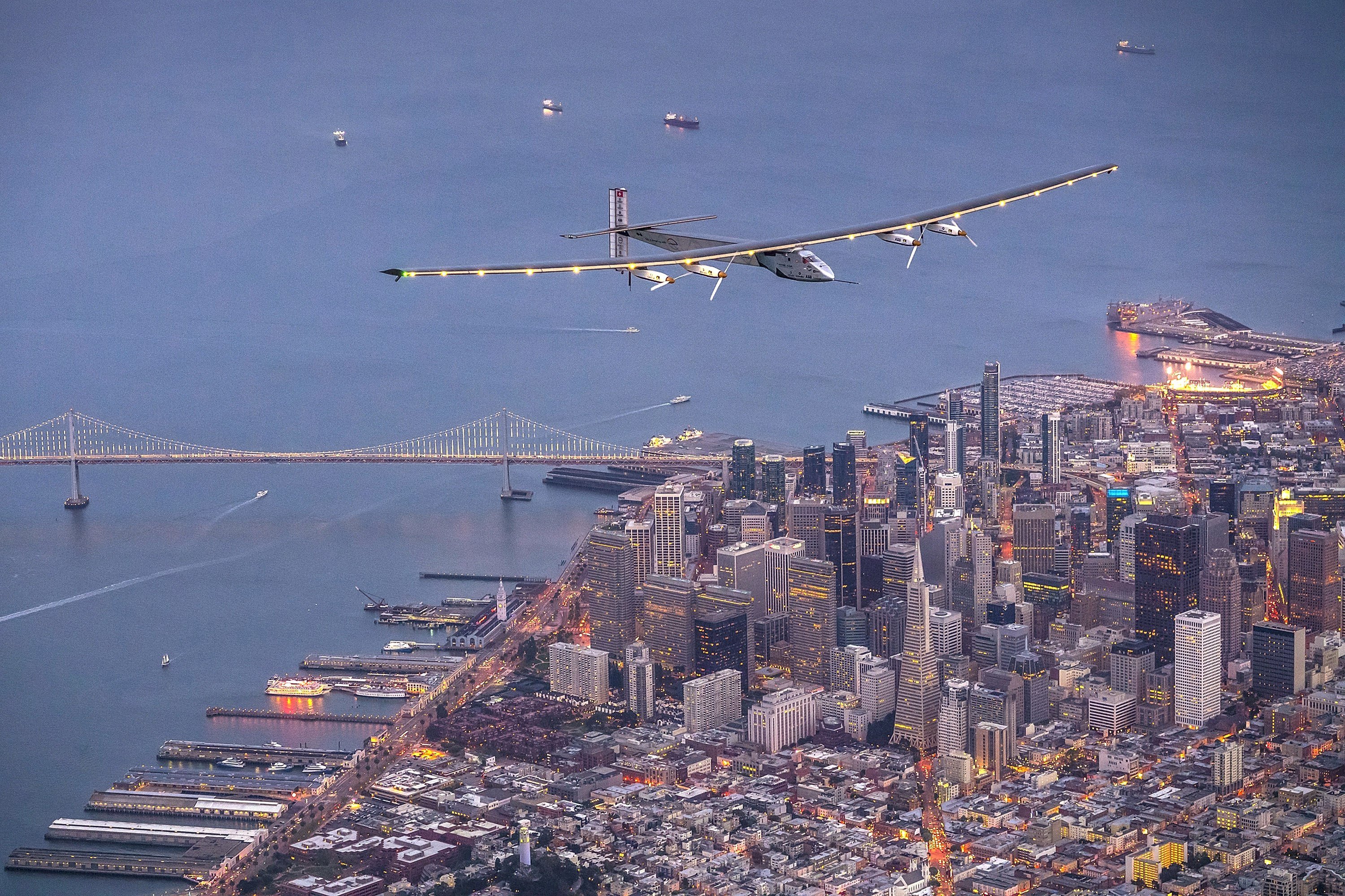 A solar-powered plane flies over San Francisco
