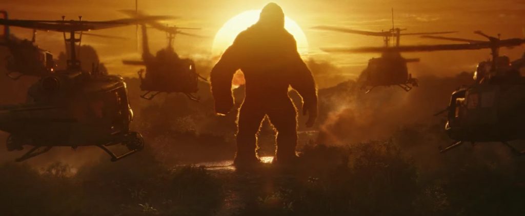 Kong stands in the sunset as helicopters approach