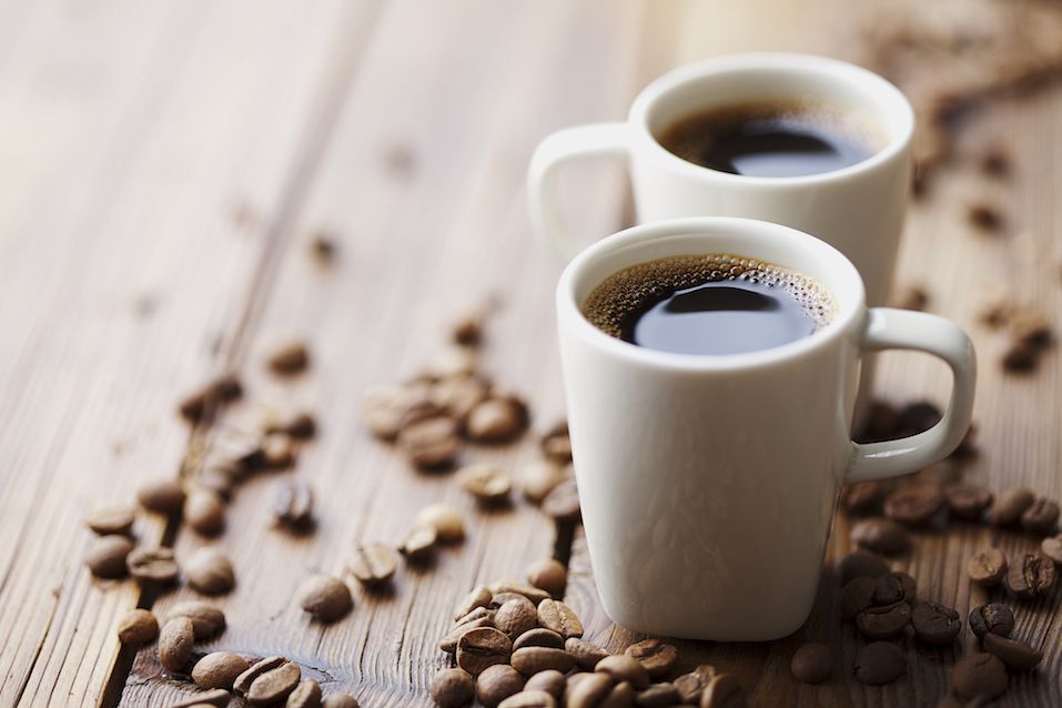 Cups of expresso surrounded by coffee beans