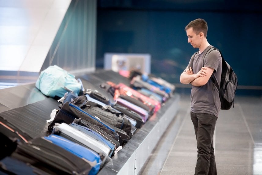 passenger waiting at conveyor belt to pick his luggage