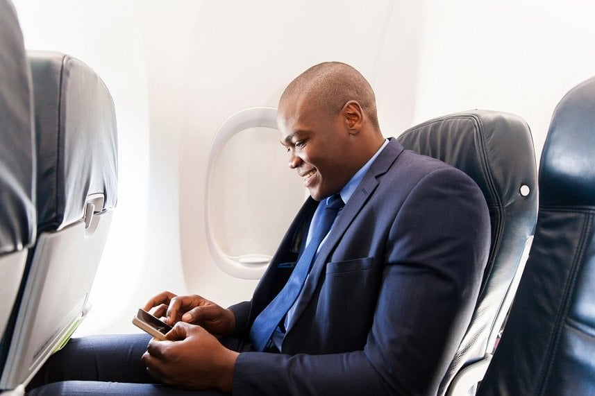 african airplane passenger using smart phone
