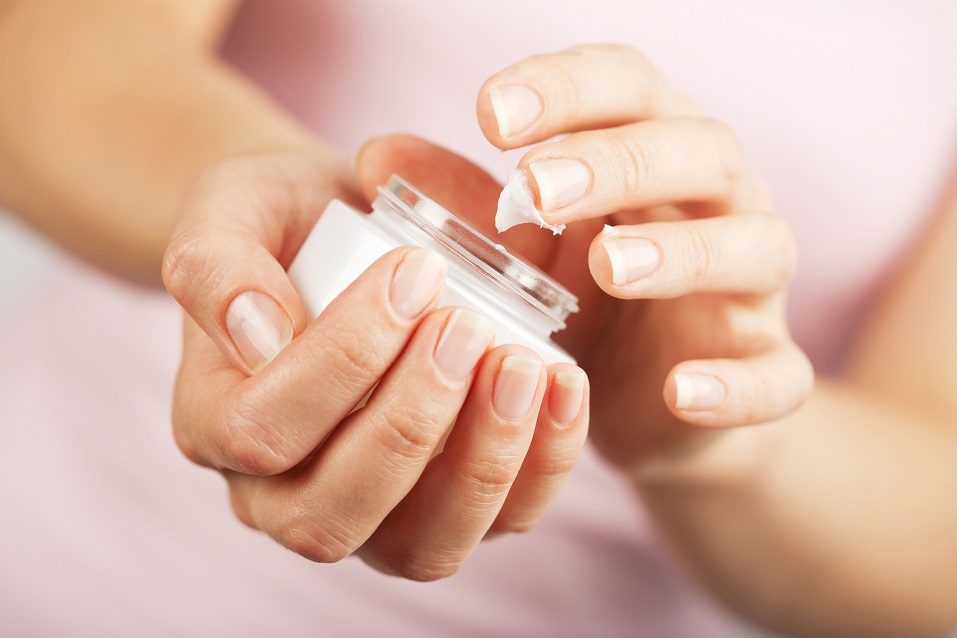 woman hands applying cream
