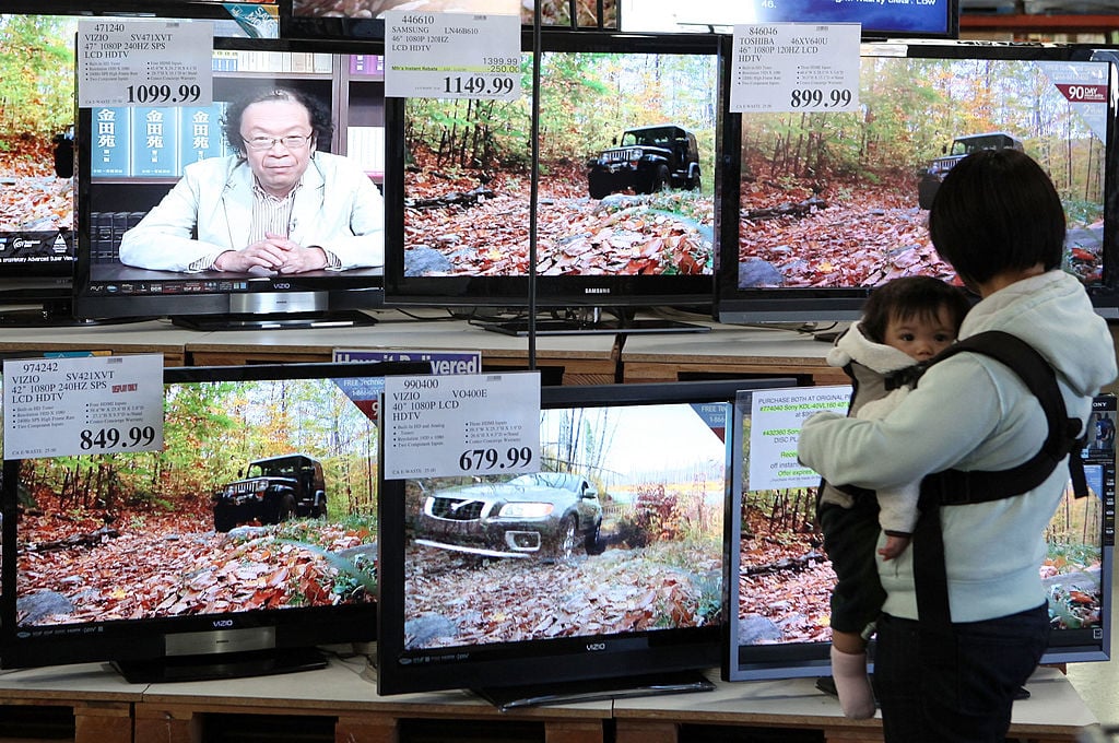 A Costco customer looks at a display of flat screen TVs