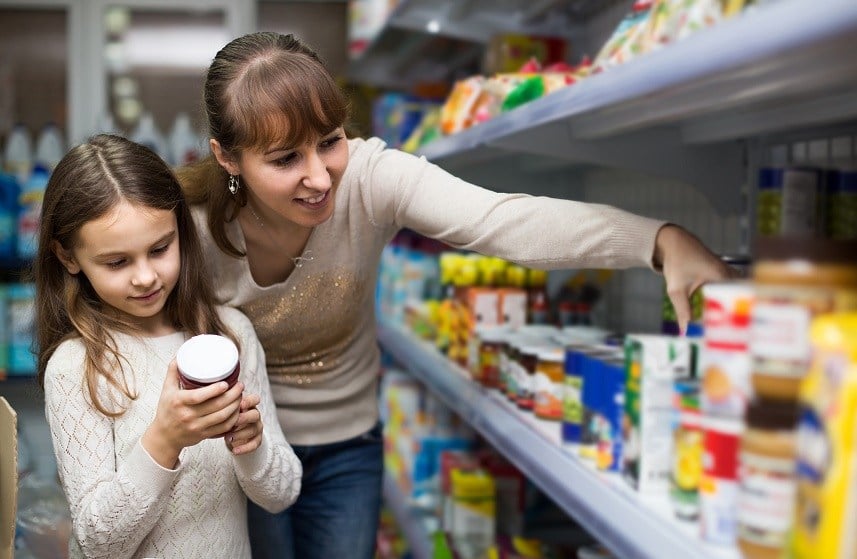 Female with daughter choosing canned goods