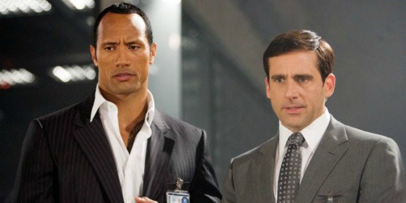 Dwayne Johnson and Steve Carrell stand next to each other in suits for Get Smart.