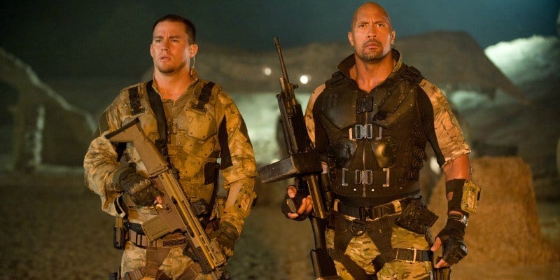 Channing Tatum and Dwayne Johnson are dressed as military men and holding guns.