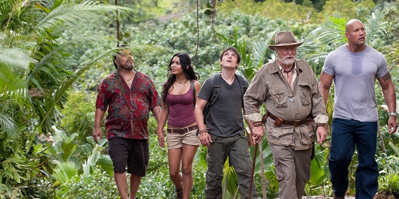 The cast of Journey 2: The Mysterious Island is walking together in a jungle.