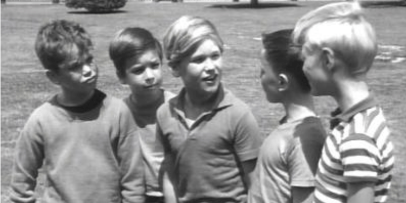 Kurt Russell in the center of young boys in Dennis the Menace.