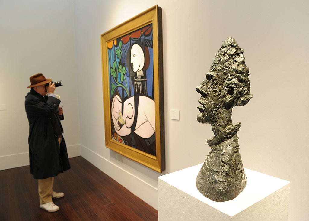 A man photographs Pablo Picasso's "Nude, Green Leaves and Bust"