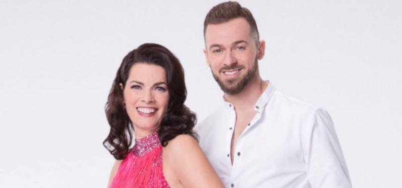 Nancy Kerrigan in a pink dress next to Artem Chigvintsev in a white shirt