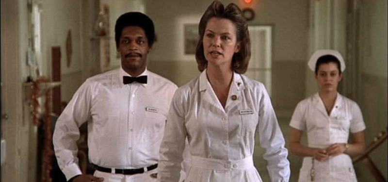 Nurse Ratched angrily walks down the hospital hall with two other workers behind her.