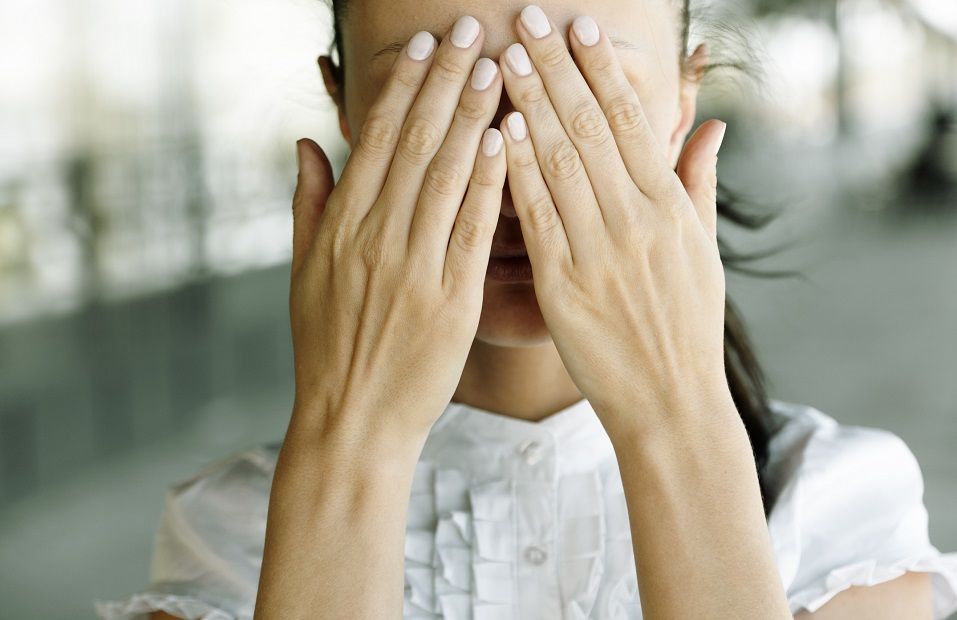 Woman with hands covering the eyes