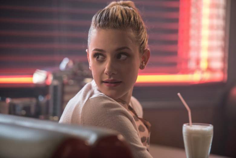 Lili Reinhart as Betty Cooper sits at a table in front of a milkshake on The CW's Riverdale