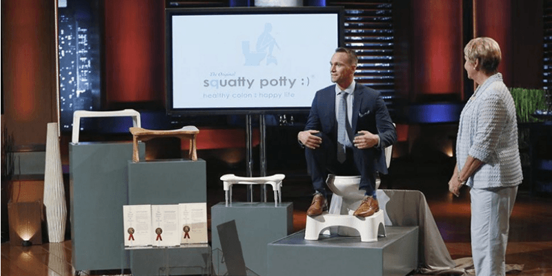 Bobby Edwards is sitting on a Squaty Potty in a suit on Shark Tank.