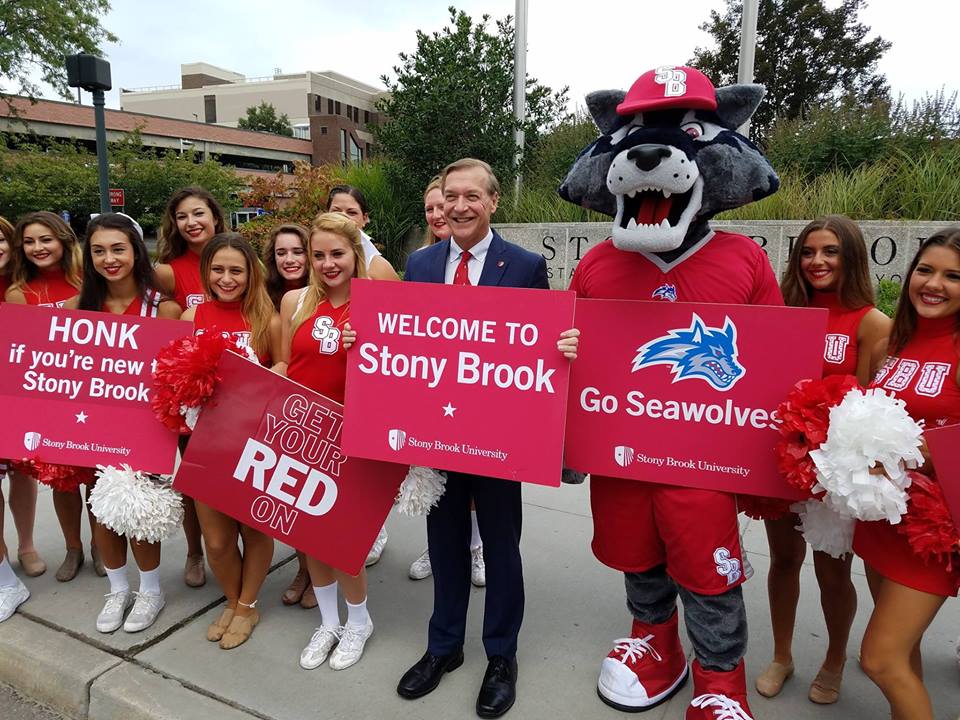 Stony Brook University students hold up welcome signs