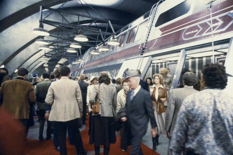 A crowd of passengers getting off a large train in a station