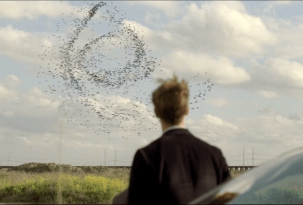Birds swirl in a curled pattern as Rust Cohle watches in a scene from the first season of HBO's 'True Detective.'