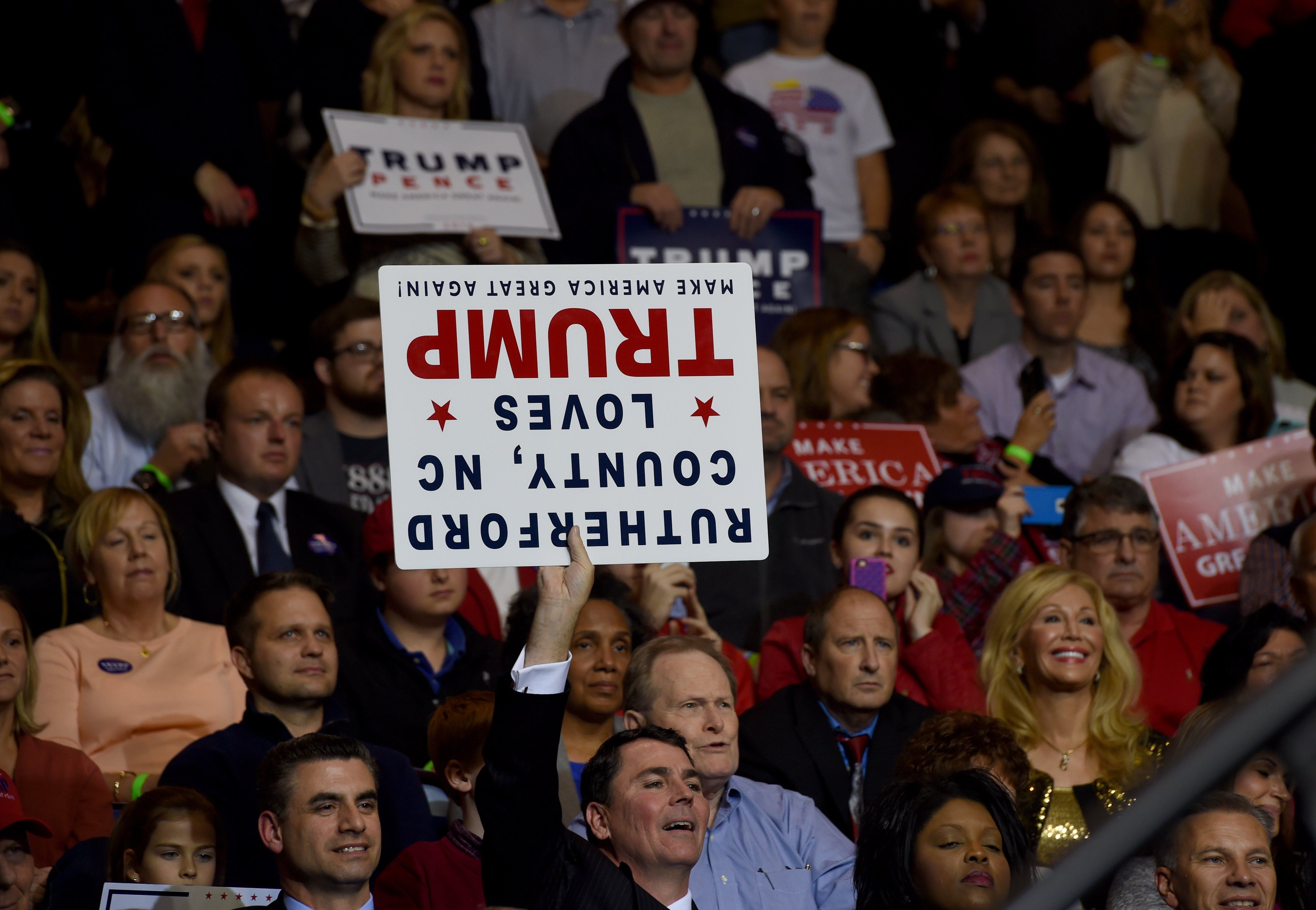 Supporters watch Donald Trump at a rally