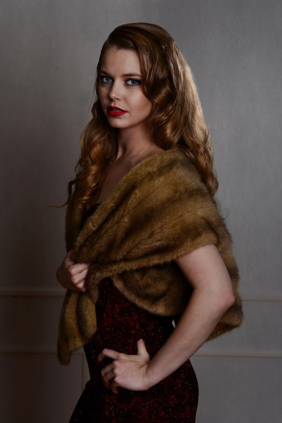 1940s glamour portrait wearing fur wrap with hand on hip