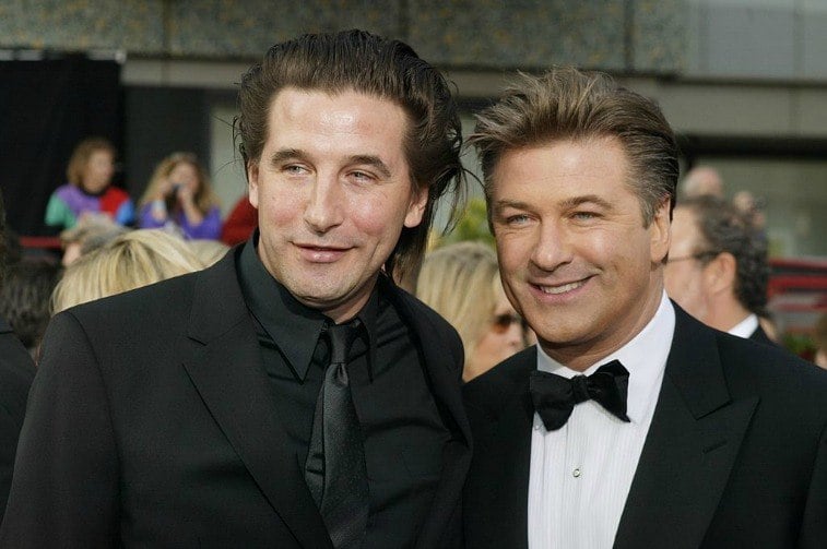 Brothers Billy Baldwin and Alec Baldwin in suits smiling for the paparazzi